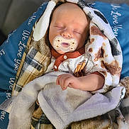 Lennox is registered to the contest to win money with this photo: baby, sleeping, pacifier, blanket, soft_texture, infant, cute, resting, wrapped, cushion, blue, patterned_blanket, comfort, peaceful, child, newborn, indoors, cozy, clothing, hand