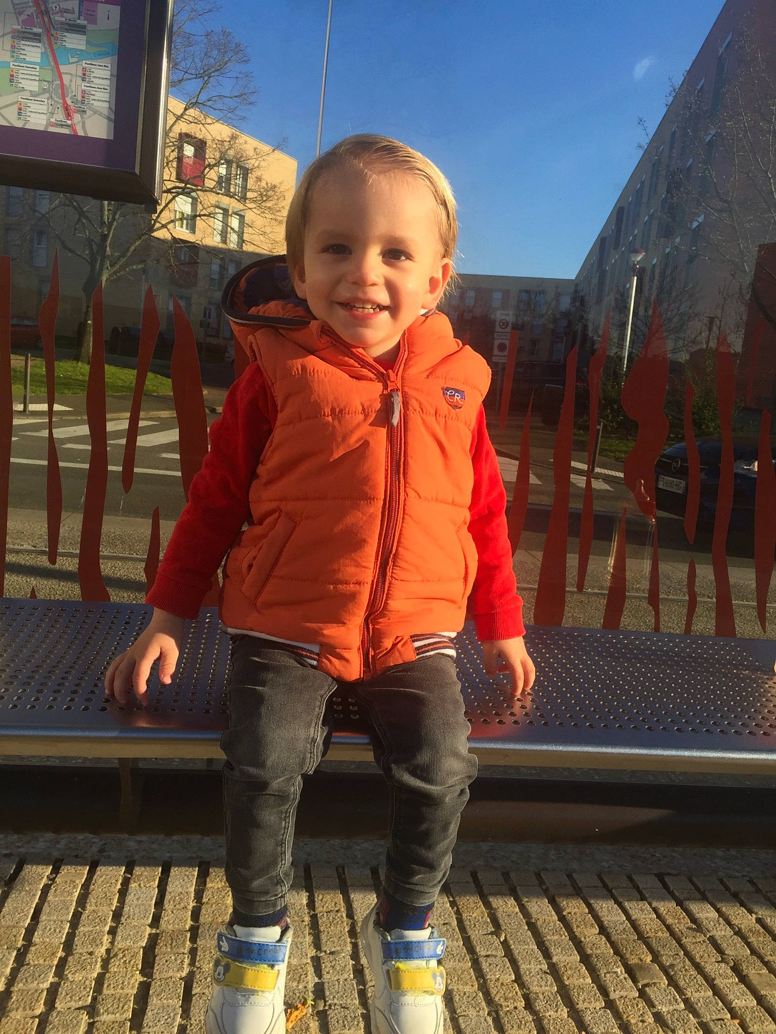 Souleyman participe au concours pour gagner de l'argent avec cette photo : baby, city, flooring, fun, happy, human_leg, jacket, joy, leg, leisure, orange, person, recreation, skin, sky, sleeve, smile, standing, toddler, travel