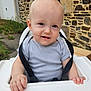 Timaël a rejoint le concours — aidez-le/la à gagner de superbes lots ! baby, child, high_chair, outdoor, stone_wall, shirt, face, hands, smile, seatbelt, person, young_child, sitting, daylight, garden, grass, window, building, safety_strap, cute
