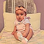 Elianna is registered to the contest to win money with this photo: baby, infant, child, pink_bow, headband, socks, knitted_blanket, pillow, purple_wall, cute, frilly_outfit, sitting, indoors, soft_lighting, portrait, toddler, curious, hand, footwear, cozy
