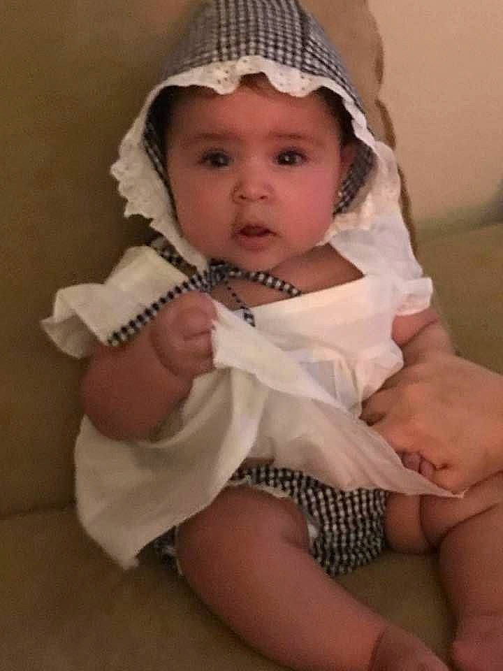 Starlynn is registered to the contest to win money with this photo: baby, beige, bonnet, child, headgear, headwear, leg, person, sitting, smile, toddler