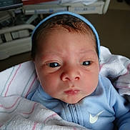Kingston is registered to the contest to win money with this photo: newborn, baby, infant, blue_clothing, blanket, hospital, face, eyes, headwear, portrait, closeup, skin, person, cute, young_child, indoors, soft_light, sleepwear, newborn_baby, wrapped