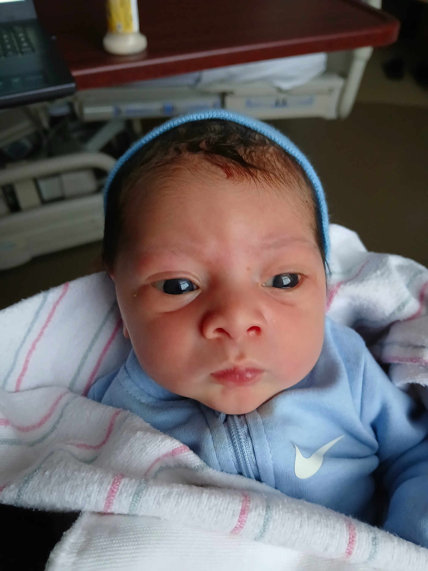 Kingston is registered to the contest to win money with this photo: newborn, baby, infant, blue_clothing, blanket, hospital, face, eyes, headwear, portrait, closeup, skin, person, cute, young_child, indoors, soft_light, sleepwear, newborn_baby, wrapped