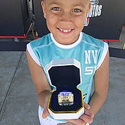Kingston is registered to the contest to win money with this photo: child, smiling, ring, box, sportswear, outdoor, concrete, toddler, happy, person, award, celebration, shorts, sleeveless_shirt, proud, face, portrait, daylight, casual, background