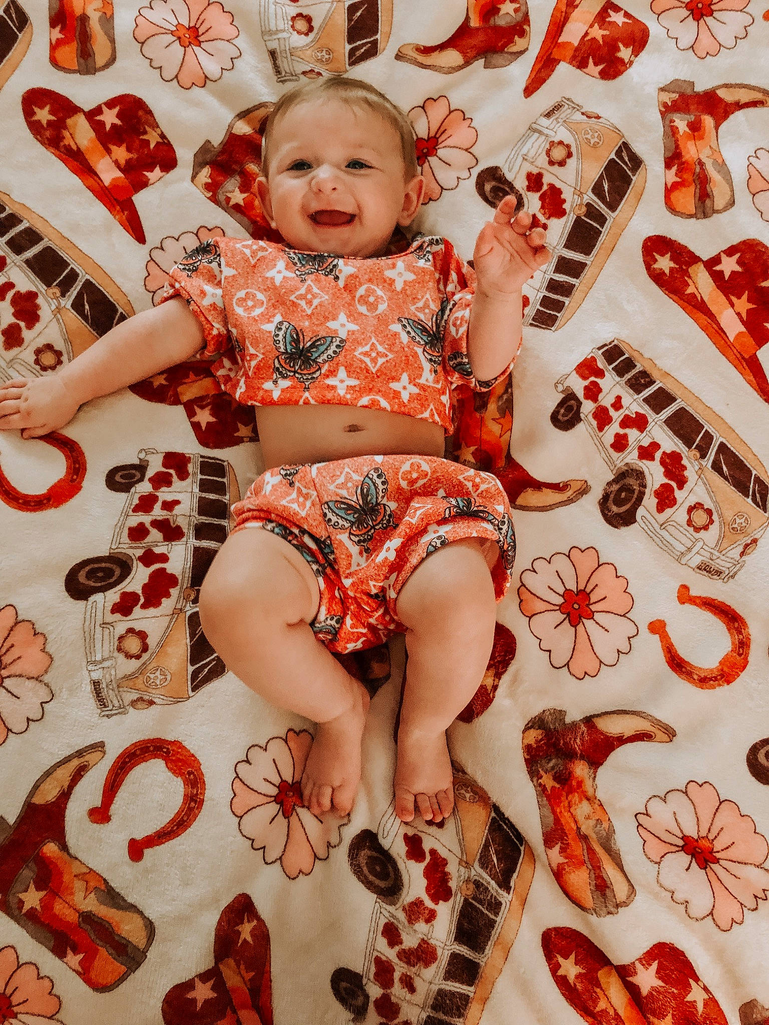 Lakelynn is registered to the contest to win money with this photo: arm, baby, baby_toddler_clothing, child, event, foot, happy, human_leg, leg, pattern, peach, person, pink, product, red, sandal, sitting, smile, thigh, toddler