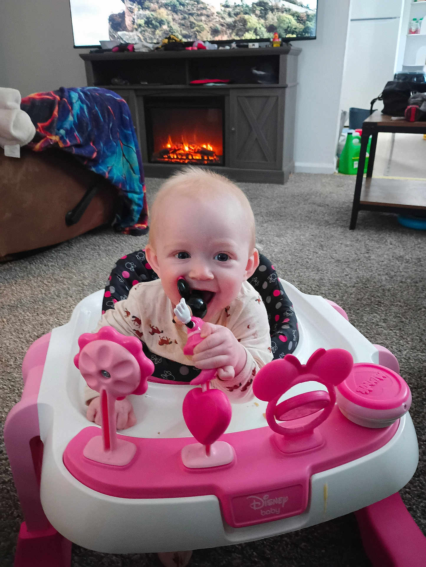 Bonnie Jo joined the competition — help win amazing prizes! baby, infant, child, pink_walker, minnie_mouse_toy, teether, smiling, chewing, playtime, living_room, fireplace, television, carpet, blanket, sofa, home_interior, hands, face, cute, plastic_toy