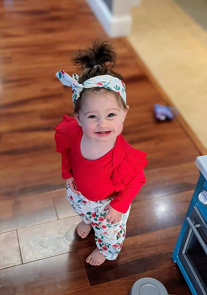 Leona is registered to the contest to win money with this photo: baby, baby_toddler_clothing, blue, child, flash_photography, flooring, fun, happy, hardwood, headband, headgear, headpiece, joy, pattern, person, purple, sleeve, smile, sock, toddler