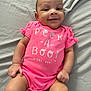 Skyler is registered to the contest to win money with this photo: baby, infant, smile, pink_onesie, clothing, lying_down, blanket, cute, happy, child, skin, face, hand, leg, indoors, portrait, young_child, playful, toddler, casual