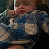 baby, child, infant, portrait, face, eyes, curious, indoor, sitting, blue_outfit, plaid, clothing, hand, knee, chair, living_room, bookshelf, home, candid, photograph