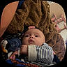 Lorenzo is registered to the contest to win money with this photo: baby, child, infant, portrait, face, eyes, surprised, indoors, blanket, cozy, striped_clothing, onesie, plush_toy, toy, lying_down, close_up, soft_lighting, home, brown_blanket, photography