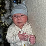 Tylio a rejoint le concours — aidez-le/la à gagner de superbes lots ! baby, bear_pattern, blurred_background, child, cute, decorations, expression, face, fist, hand, hat, holiday, indoor, infant, lights, newborn, onesie, portrait, texture, wall