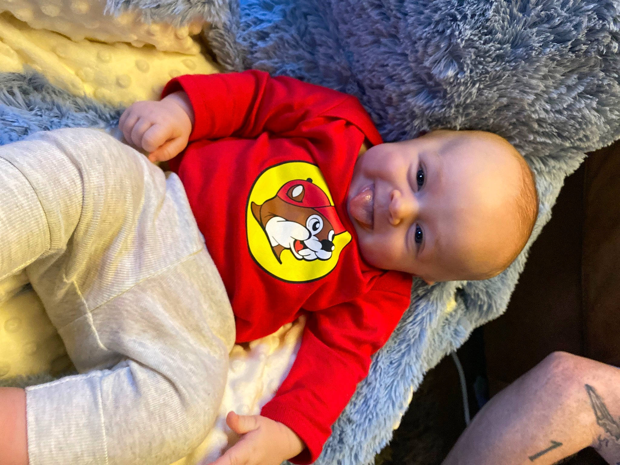 Travis is registered to the contest to win money with this photo: baby, baby_toddler_clothing, blue, child, comfort, event, eye, fun, happy, hat, leisure, mouth, nose, organ, person, sitting, skin, sleeve, smile, t_shirt