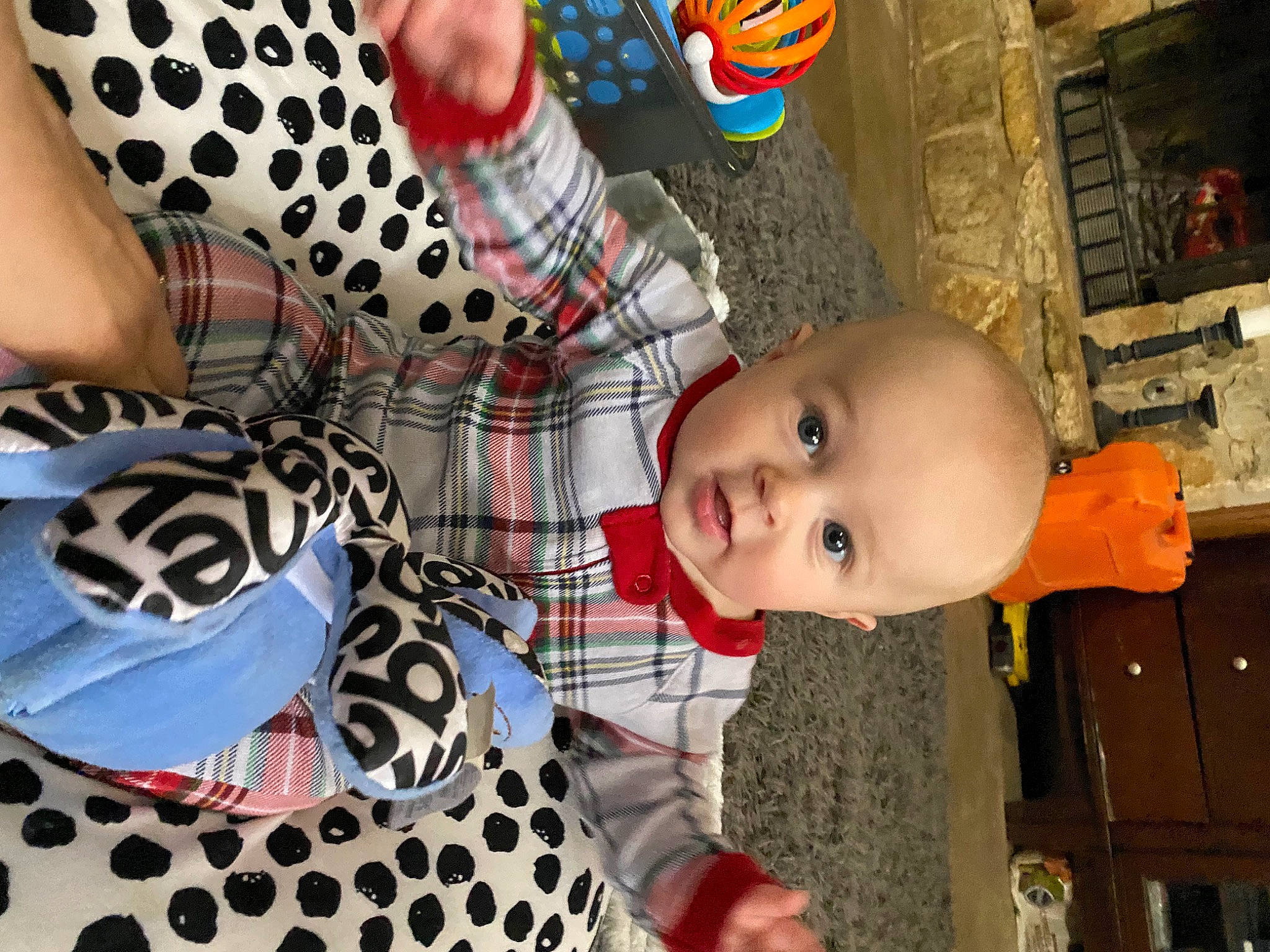 Travis is registered to the contest to win money with this photo: baby, baby_products, baby_toddler_clothing, baby_toys, carmine, child, design, fashion_accessory, gesture, happy, pattern, person, photograph, picture_frame, plaid, sleeve, tartan, textile, toddler, toy