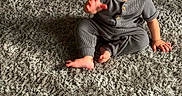 Jayden is registered to the contest to win money with this photo: baby, child, infant, sitting, waving, wide_eyed, serious_expression, portrait, indoor, rug, carpet, gray, sunlight, shadows, onesie, striped_clothing, barefoot, floor, photography, adorable