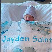 Jayden joined the competition — help win amazing prizes! newborn, baby, blanket, hospital, bassinet, sleeping, hat, infant, bed, clothing, cute, face, peaceful, resting, soft, elephant_print, blue, white, person, indoors