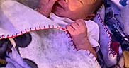Kylo is registered to the contest to win money with this photo: newborn, baby, infant, sleeping, lying_down, blanket, swaddled, nursery, stuffed_animal, plush_toy, crib, portrait, face, hands, cozy, indoors, soft_lighting, child, bedtime, cuddly