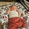 baby, infant, sleeping, portrait, indoors, blanket, animal_print, onesie, pants, socks, bed, cozy, peaceful, lying_down, closed_eyes, face, clothing, home, soft_lighting, relaxed