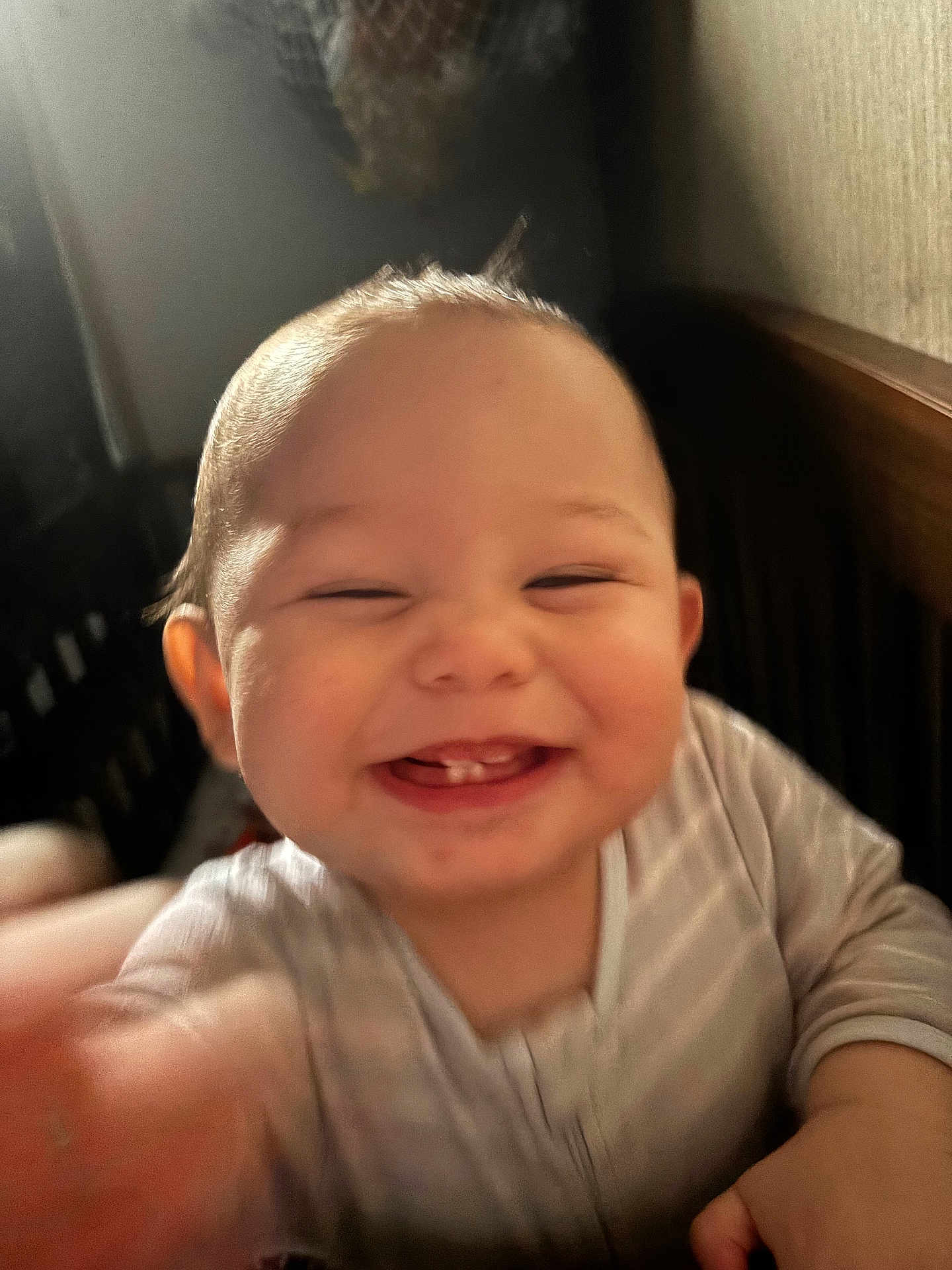 Lyndon is registered to the contest to win money with this photo: baby, smiling, teeth, face, hand, infant, joy, happiness, indoor, blur, closeup, person, child, cute, young, expression, blurred_motion, wearing, striped_clothing, head