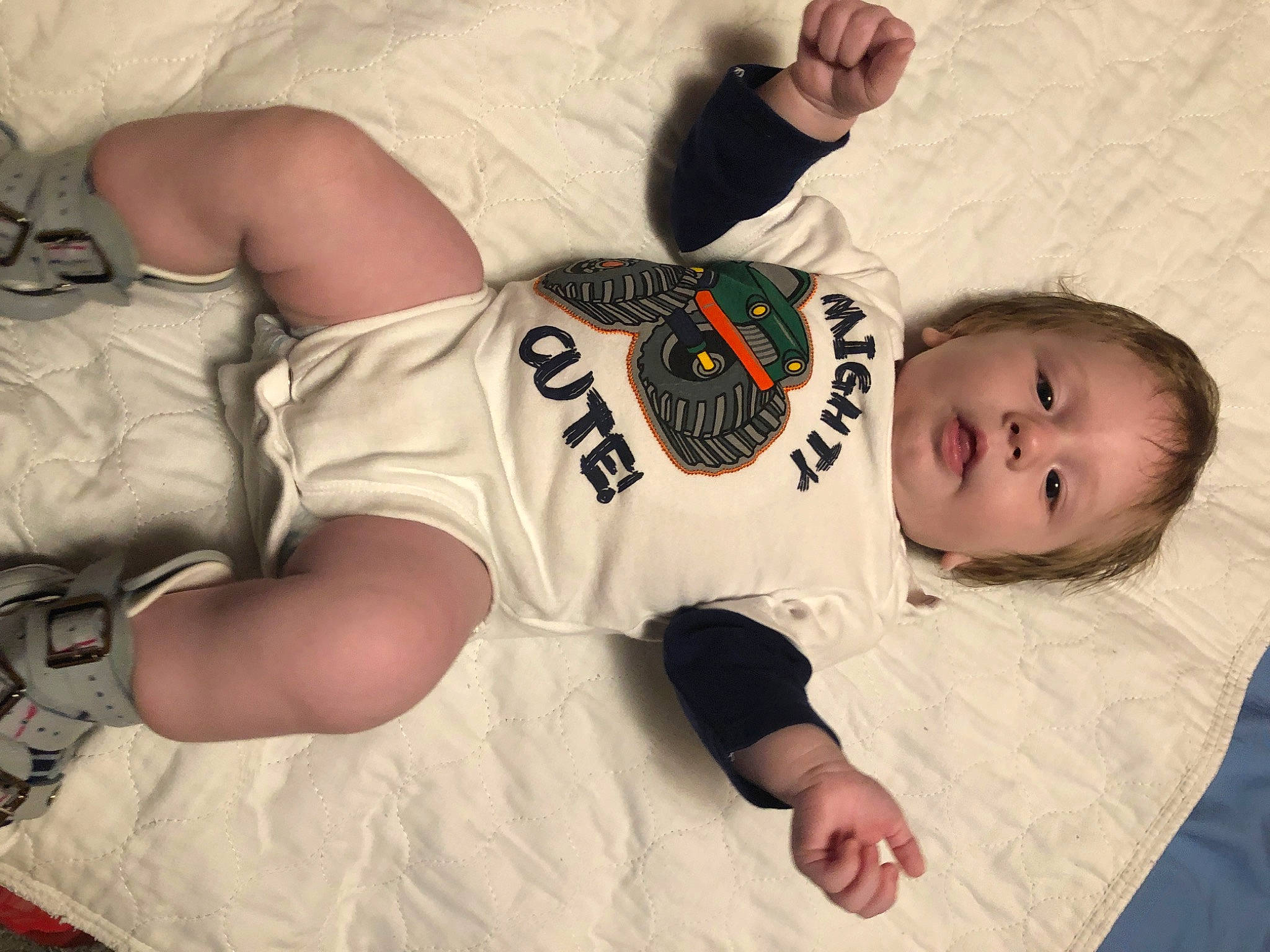 Eric is registered to the contest to win money with this photo: baby, baby_toddler_clothing, child, comfort, elbow, finger, flooring, happy, human_leg, infant_bodysuit, linens, mouth, pattern, person, sitting, sleeve, t_shirt, thigh, toddler, wood