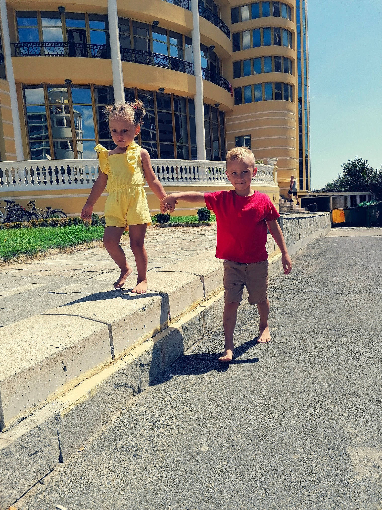 Ema participe au concours pour gagner de l'argent avec cette photo : asphalt, building, city, eyewear, human_leg, joy, leg, leisure, pedestrian, person, recreation, road, road_surface, shorts, sidewalk, sky, standing, street_fashion, t_shirt, thigh