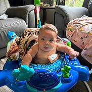 Weston joined the competition — help win amazing prizes! baby, child, infant, activity_walker, toy, indoor, living_room, armchair, blanket, blue, sitting, face, portrait, wide_eyed, curious, floor, window, daylight, household, playtime