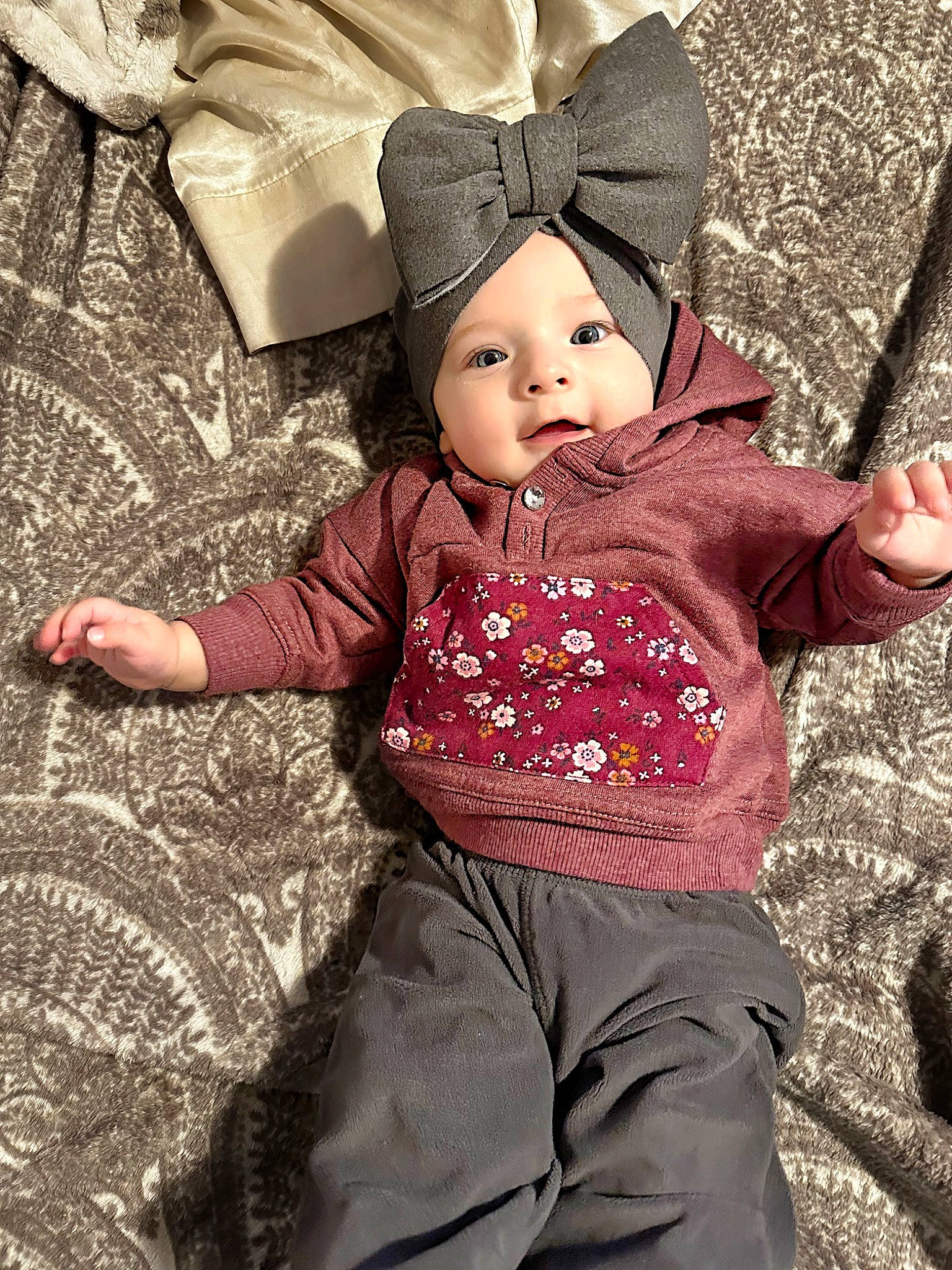 Amira joined the competition — help win amazing prizes! baby, baby_products, baby_toddler_clothing, beanie, cap, child, clothing, fur, grass, happy, hat, headwear, magenta, pattern, people_in_nature, person, sitting, sleeve, t_shirt, toddler