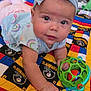 baby, child, headband, toy, quilt, colorful, indoor, face, hand, clothing, blue, pink, pattern, soft_toys, floor, person, crawling, infant, cute, playtime