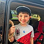 child, boy, smile, cap, tshirt, spiderman, car, car_door, car_seat, seatbelt, hand, window, sunlight, outdoor, happy, portrait, vehicle_interior, casual_clothing, young, person