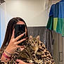 person, cat, kitten, mirror, selfie, bathroom, towel, animal_print, long_nails, bracelet, smartphone, reflection, striped_cat, holding, cute, indoor, casual, portrait, young_adult, feline