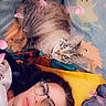 bed, blanket, cat, charm, collar, cozy, cute, filter, flowers_overlay, glasses, indoor, looking_at_camera, lying_down, person, pet, petals, pillow, portrait, selfie, tabby_cat