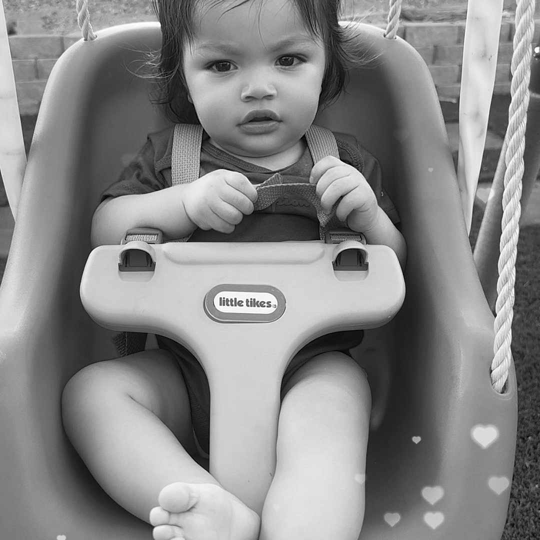 Prince Arsiah is registered to the contest to win money with this photo: toddler, child, swing, playground, outdoor, baby, seat, ropes, grass, black_and_white, portrait, cute, hands, feet, expression, toy, safety, young_child, face, hair