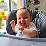 Alba participe au concours pour gagner de l'argent avec cette photo : baby, high_chair, smiling, indoor, child, happy, toddler, clothing, person, hair_clip, face, window, plant, furniture, daylight, skin, seat, cute, infant, expression