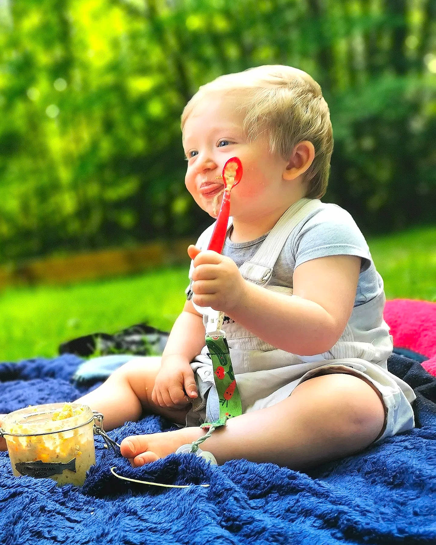 Logan participe au concours pour gagner de l'argent avec cette photo : baby, baby_laughing, baby_toddler_clothing, blond, child, facial_expression, fun, grass, happy, leaf, leisure, people_in_nature, person, plant, recreation, sitting, smile, summer, sunlight, toddler