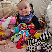 Laïla participe au concours pour gagner de l'argent avec cette photo : baby, child, plush_toys, cushions, colorful, smile, indoors, soft_toys, cute, sitting, blanket, playtime, happy, face, person, comfort, cozy, room, infant, fun