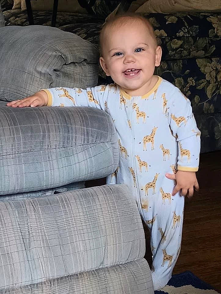 Charlotte is registered to the contest to win money with this photo: baby, baby_toddler_clothing, cheek, child, collar, comfort, couch, electric_blue, eye, face, happy, head, joy, linens, pattern, person, sitting, skin, sleeve, smile