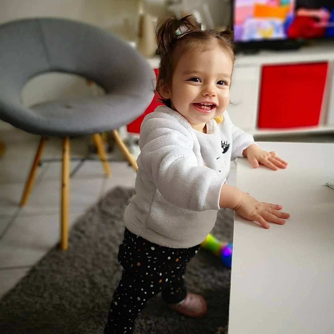Noélïa participe au concours pour gagner de l'argent avec cette photo : baby, baby_toddler_clothing, child, comfort, floor, flooring, fun, happy, joy, leisure, pattern, person, play, room, shorts, sitting, sleeve, smile, standing, t_shirt