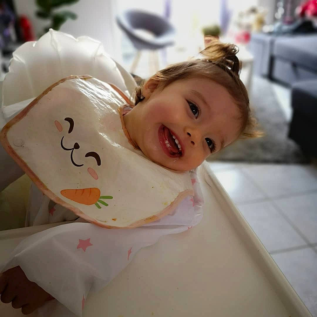 Noélïa a rejoint le concours — aidez-le/la à gagner de superbes lots ! baby, baby_toddler_clothing, cheek, child, dress, event, fashion_accessory, flooring, fun, hair_accessory, happy, mammal, person, room, sitting, skin, sleeve, smile, toddler