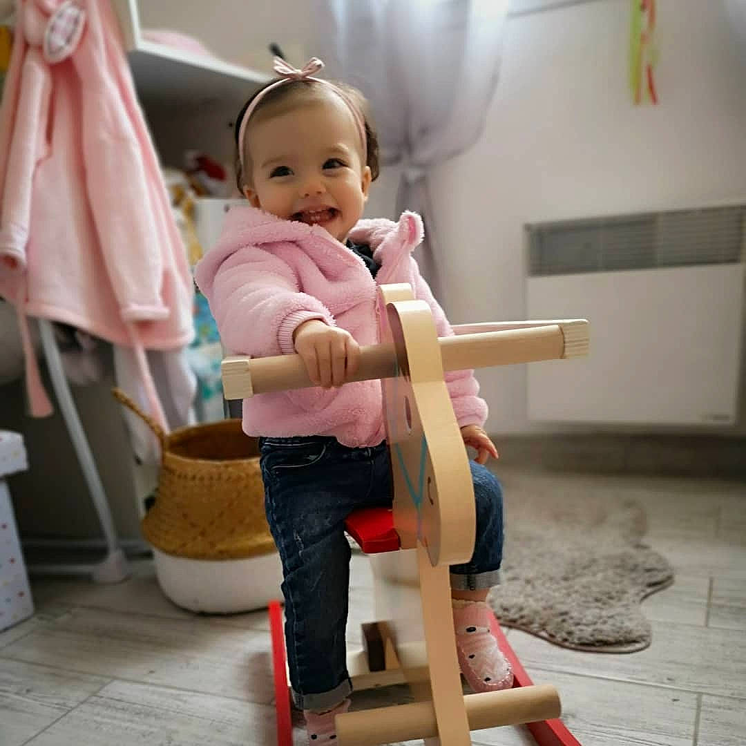 Noélïa participe au concours pour gagner de l'argent avec cette photo : baby, baby_products, baby_safety, baby_toddler_clothing, chair, comfort, fun, hairstyle, happy, human_body, human_leg, knee, peach, person, room, sitting, sleeve, smile, toddler, wheel