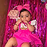 baby, background, bracelet, celebration, chewing, child, cute, doll, dress, happy, headband, indoors, necklace, person, pink, playful, portrait, purse, ribbon, streamers