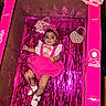 Leylani joined the competition — help win amazing prizes! 9_months, accessories, baby, box, celebration, child, cute, decorations, dress, headband, indoors, infant, lying_down, milestone, party, pearl_bag, pink, portrait, shoes, streamers