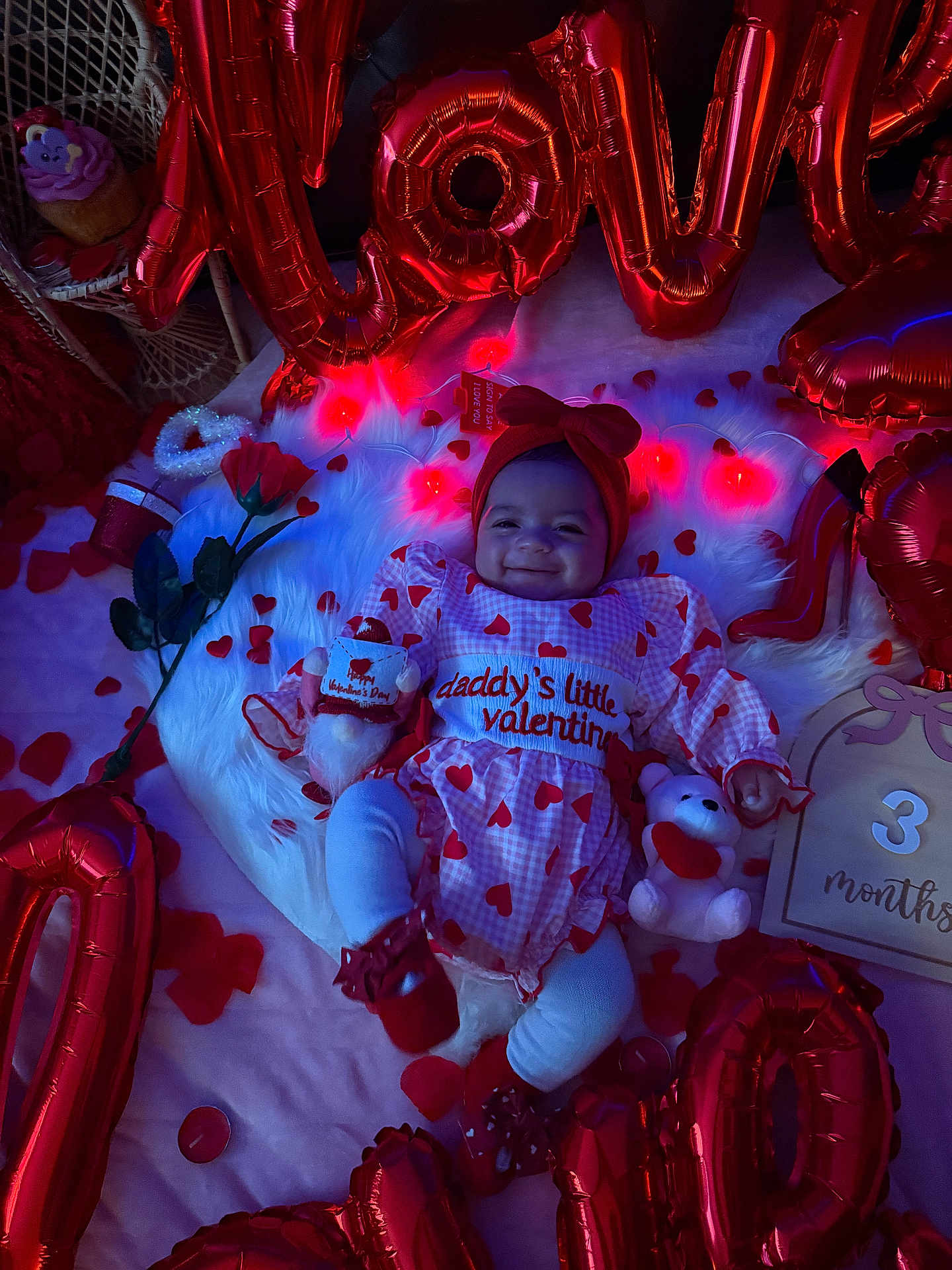 Leylani joined the competition — help win amazing prizes! baby, infant, smile, valentine, heart_pattern, red_balloons, foil_balloons, headband, bow, plush_toy, teddy_bear, rose, petals, fur_rug, milestone_card, outfit, holiday_decor, celebration, soft_lighting, photo_shoot