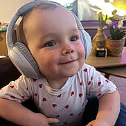 Mayve participe au concours pour gagner de l'argent avec cette photo : baby, child, cute, expression, face, furniture, happy, headphones, hearts, indoor, living_room, person, plant, portrait, shirt, smiling, table, technology, toddler, vase