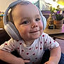 baby, child, cute, expression, face, furniture, happy, headphones, hearts, indoor, living_room, person, plant, portrait, shirt, smiling, table, technology, toddler, vase