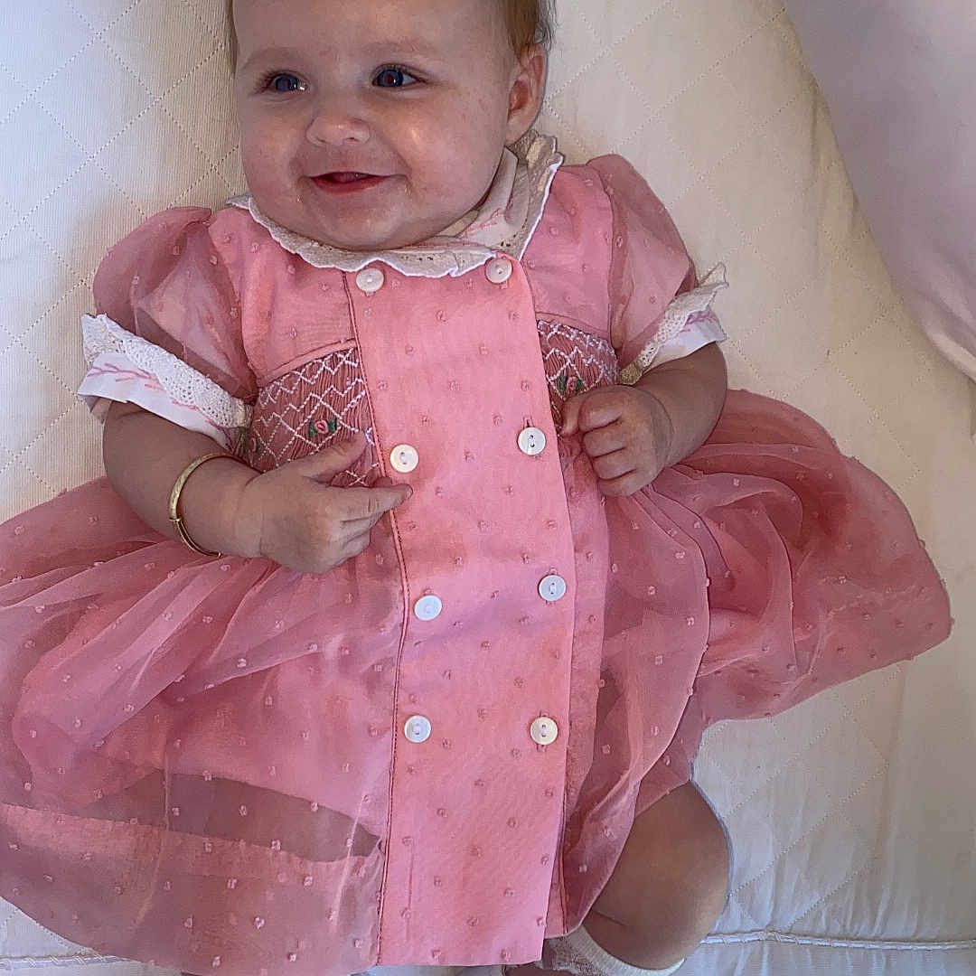 Renesmae joined the competition — help win amazing prizes! baby, bodypart, clothing, couch, dress, face, finger, footwear, formalwear, furniture, hand, head, homedecor, pants, person, photography, portrait, sandal, shoe, sitting