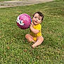 baby, child, grass, ball, outdoor, toy, playing, smiling, curly_hair, yellow_onesie, driveway, car, house, suburban, daytime, nature, greenery, happy, sitting, person