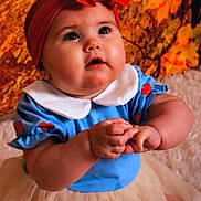 Isla-Grace is registered to the contest to win money with this photo: baby, child, toddler, blue_clothing, red_headband, bow, tutu, cute, portrait, indoors, autumn, leaves, background, chubby_cheeks, hands, expression, curious, sitting, young_child, face