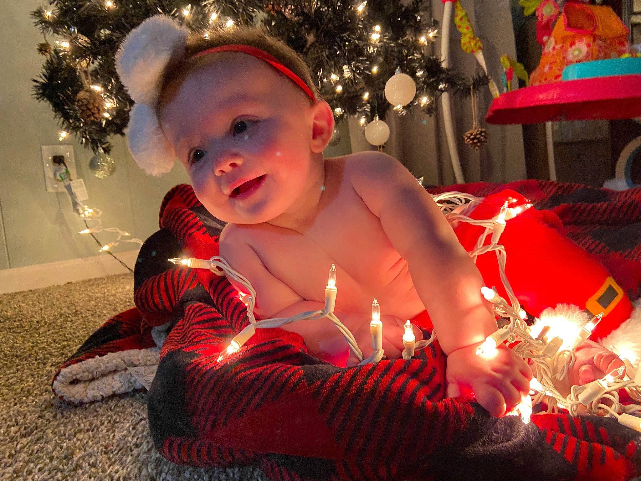 Dani is registered to the contest to win money with this photo: baby, candle, child, christmas, christmas_decoration, christmas_eve, christmas_ornament, christmas_tree, event, fun, happy, holiday, holiday_ornament, lap, light, lighting, ornament, person, red, smile