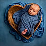 baby, blue_background, blue_blanket, child, cozy, cute, heart_shaped_bowl, infant, newborn, newborn_photography, peaceful, portrait, sleeping, small, soft_lighting, studio_photo, swaddled, tiny_feet, wooden_bowl, wrapped