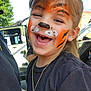 Madilynn joined the competition — help win amazing prizes! black_shirt, child, closeup, colorful, cute, daylight, face_paint, fun, happy, jewelry, necklace, outdoor, person, portrait, smiling, sunny, tiger_face_paint, tree, vehicle, young