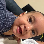 Thiago joined the competition — help win amazing prizes! baby, infant, child, face, portrait, close_up, smiling, happy, curious, eyes, open_mouth, striped_clothing, indoor, cozy, blanket, adult, person, reclining, photography, head